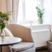 Ein stilvoller Stuhl, dekoriert mit einer Vase, die mit leuchtenden Blumen gefüllt ist und Freude ausstrahlt.