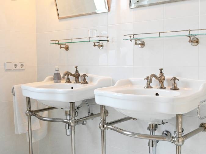 Stilvolles Badezimmer mit zwei Waschbecken und Spiegeln, das Funktionalität und Eleganz vereint.