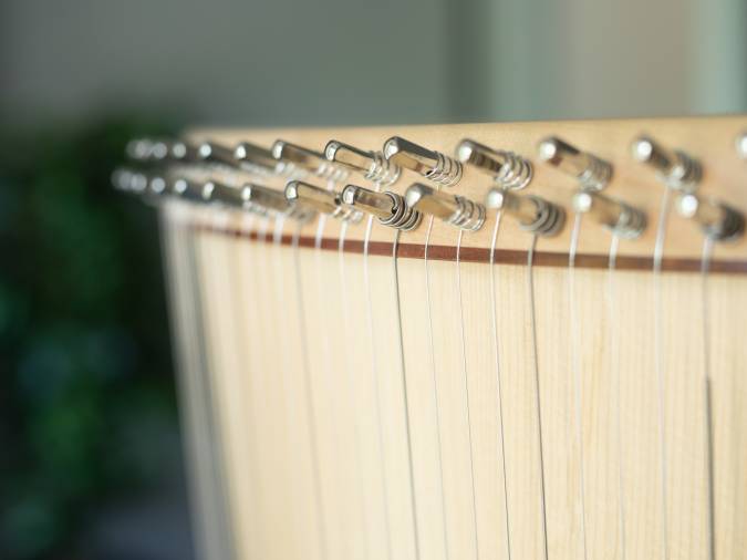 Nahaufnahme einer Harfe mit vielen Saiten, die die heilende Kraft der Musiktherapie symbolisiert.