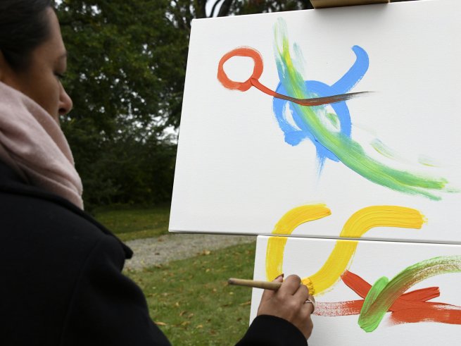 Eine Frau malt ein Bild zum Geburtstag des Klinikum Schloss Lütgenhof, voller Kreativität und Freude.